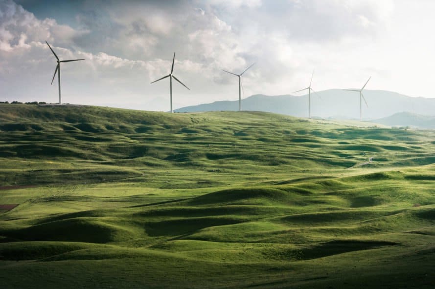 windmills on rolling green hills