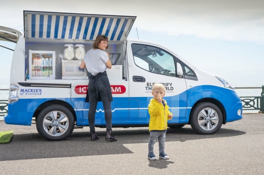 child eating ice cream next to white ice cream van